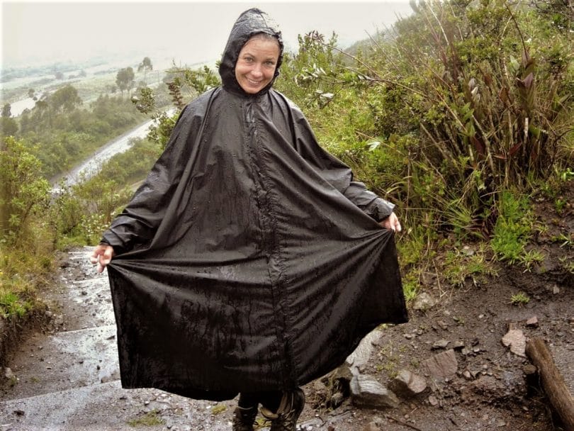 woman wearing a black gore tex poncho in the rain
