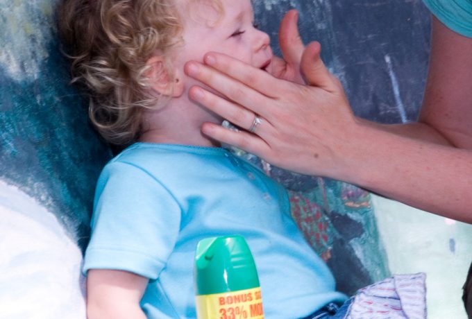 Mother putting insect repellent on toddler