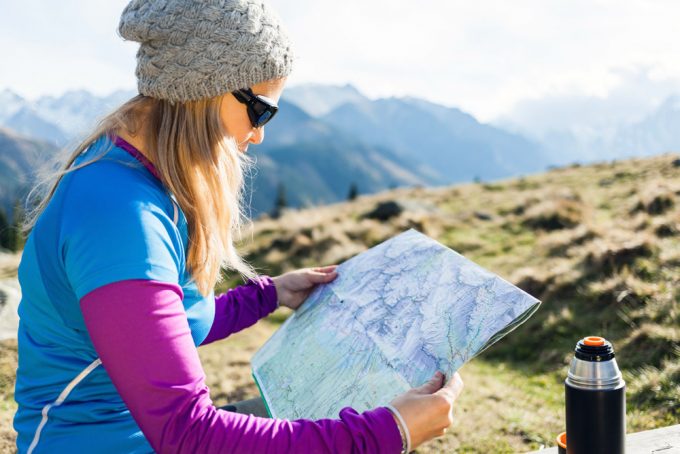 Woman hiker reading and checking map
