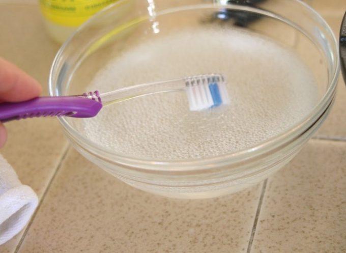 dipping toothbrush in cleaning solution