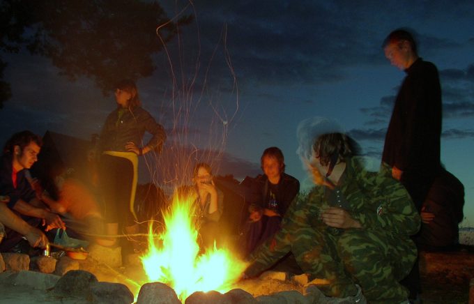 friends gathered around campfire