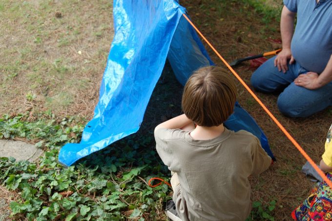 kid and dad making tarp tent