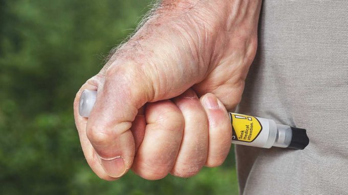 man using and Epipen