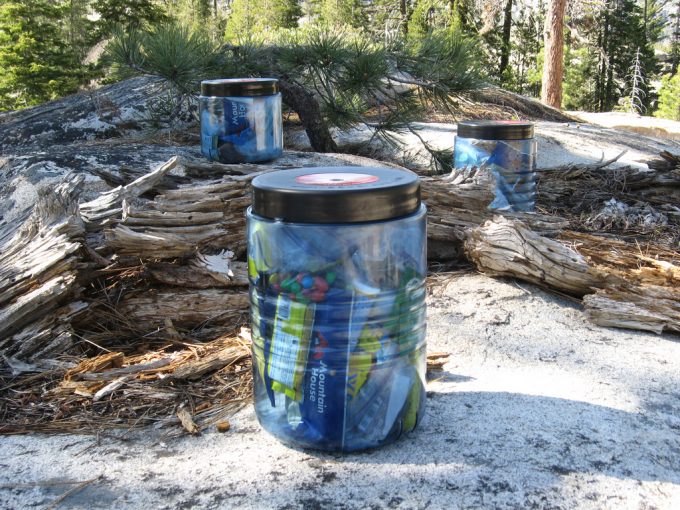 three bear canisters in the woods