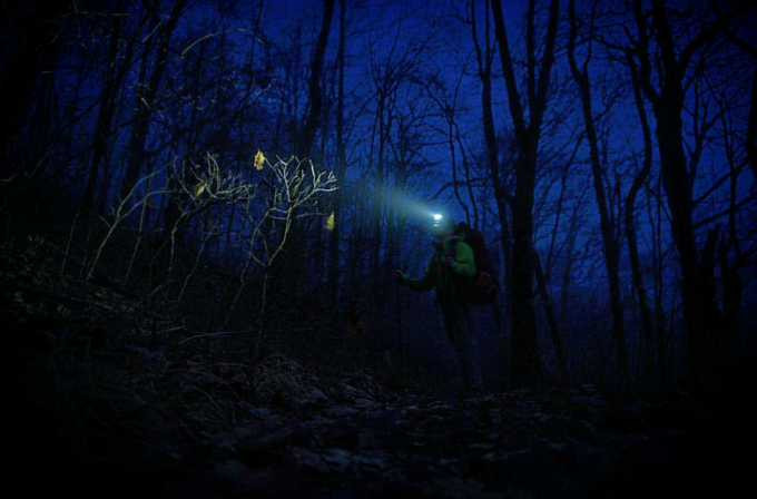 hiker alone in the woods at night